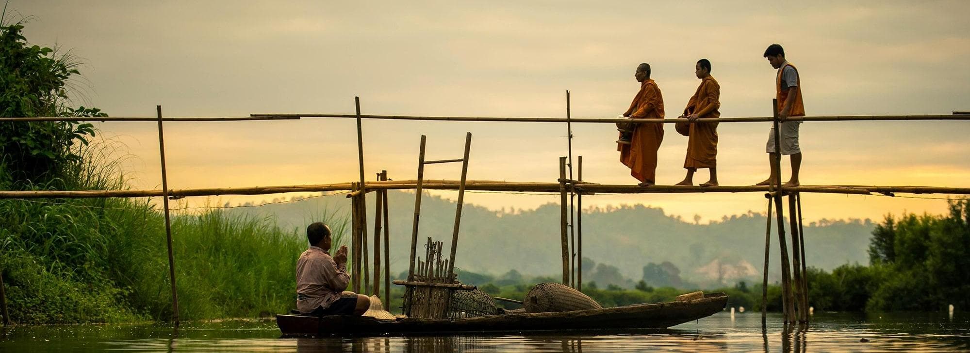 Monaci Thailandesi venerati da un pescatore dalla sua zattera