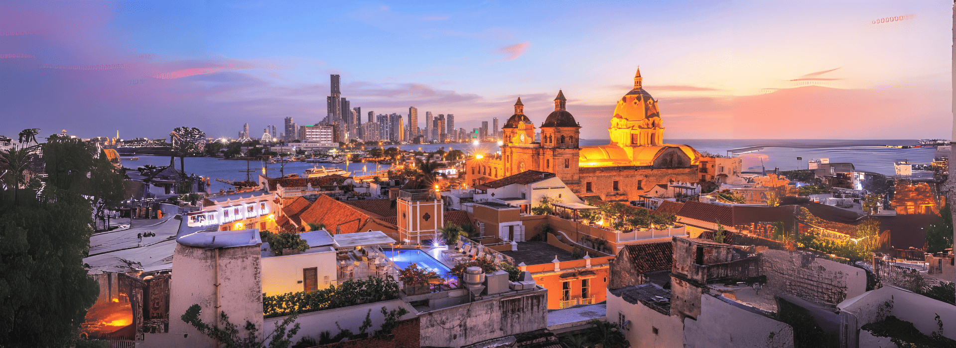 Vista panorámica del centro histórico de Cartagena al atardecer con la cúpula iluminada de la Catedr
